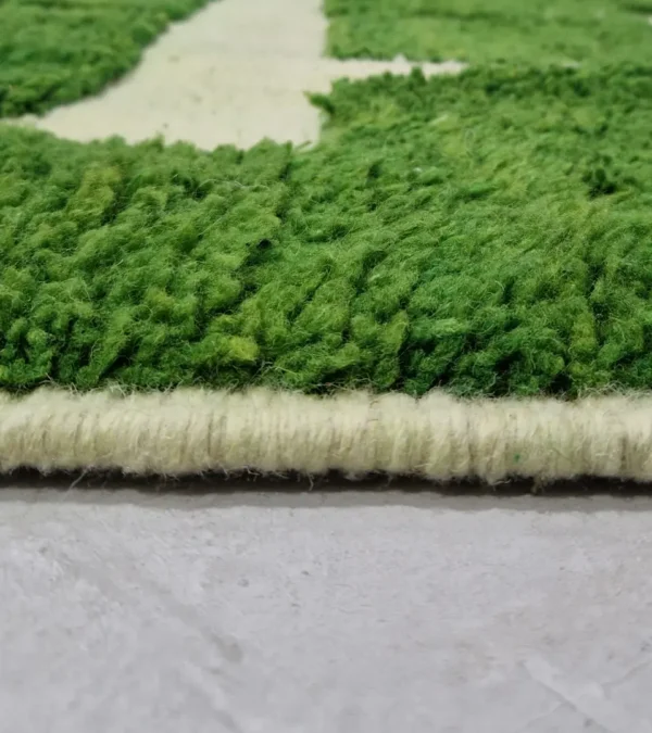 Zoomed In View of Frez handmade wool rug with a minimalist green line pattern and ivory background