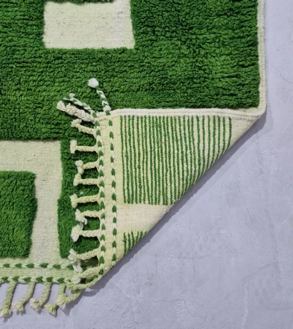 Detailed View of Frez handmade wool rug with a minimalist green line pattern and ivory background