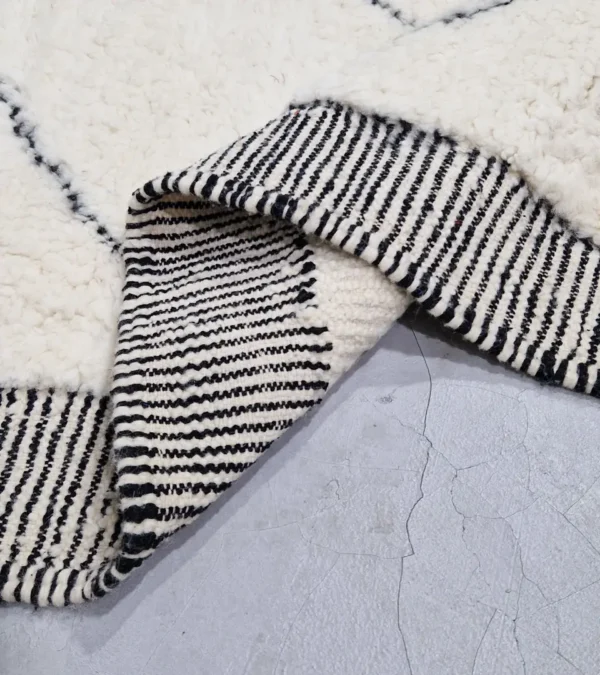 Detailed View of Ghita handmade Beni Ourain wool rug with a classic dark diamond pattern on an ivory background