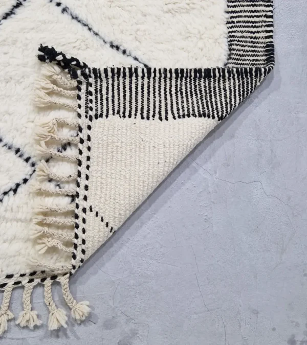 Detailed View of Ghita handmade Beni Ourain wool rug with a classic dark diamond pattern on an ivory background