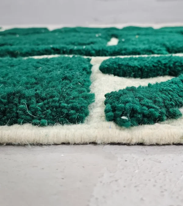 Zoomed In View of Handmade Beni Ourain wool rug with a high/low textured pile and a forest green geometric design