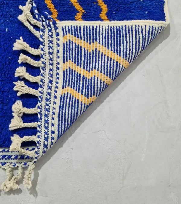 Detailed View of Handwoven Moroccan rug with a jagged blue and beige design and yellow zigzag lines