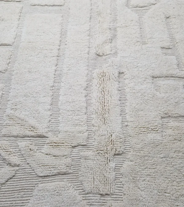 Detailed View of handmade Moroccan wool rug with a subtle geometric design created by varying pile heights in neutral tones