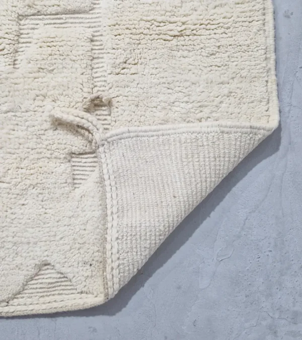 Detailed View of handmade Moroccan wool rug with a subtle geometric design created by varying pile heights in neutral tones