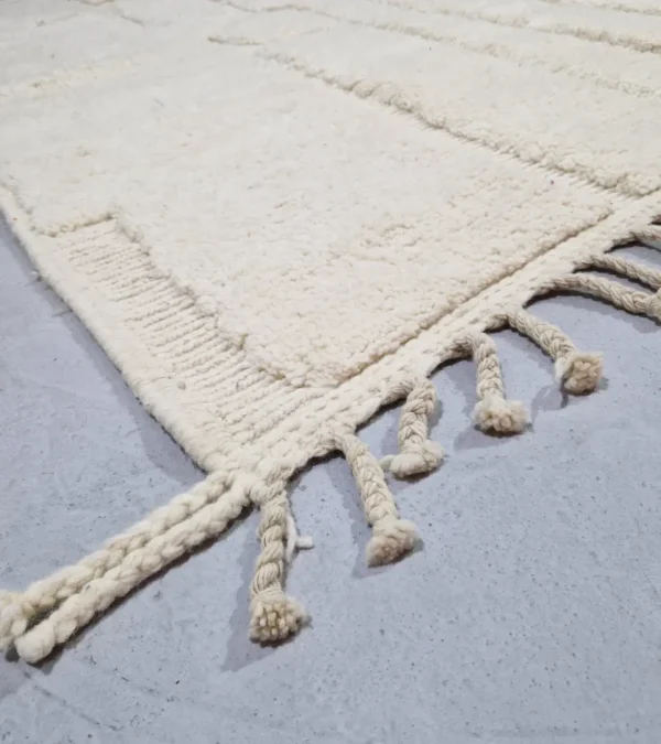 Detailed View of handmade Moroccan wool rug with a subtle geometric design created by varying pile heights in neutral tones