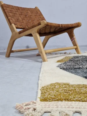 Imani handmade Beni Ourain wool rug with an abstract geometric design in charcoal gray, mustard yellow, and ivory in room