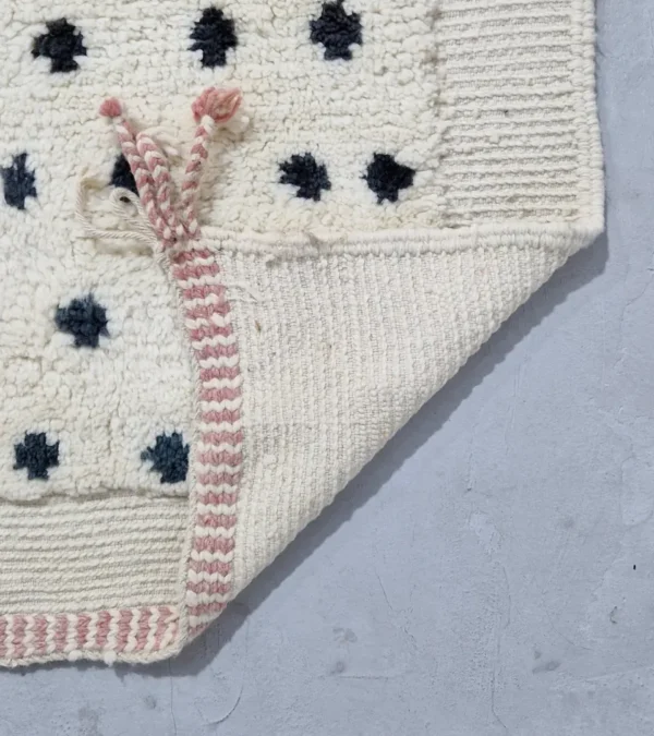 Detailed View of Johana handmade Moroccan wool rug with a modern dotted pattern and two-tone green and ivory design