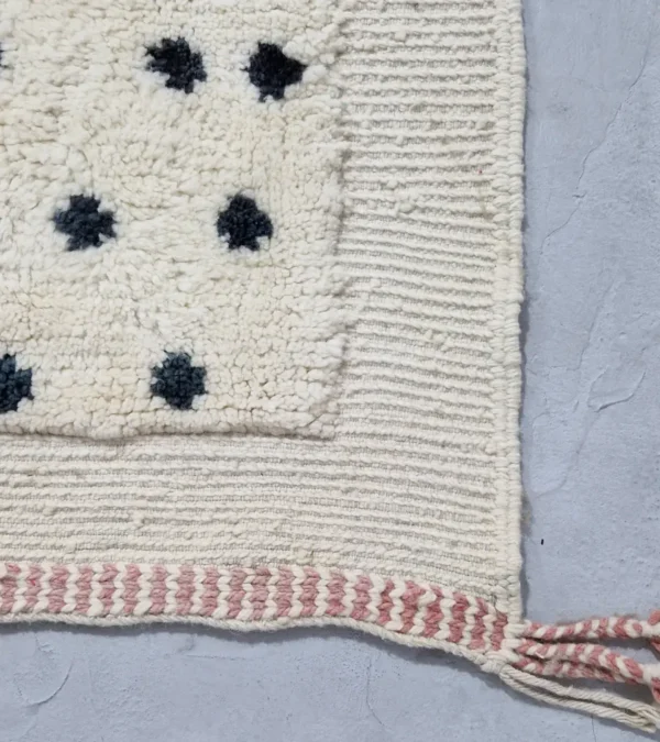 Detailed View of Johana handmade Moroccan wool rug with a modern dotted pattern and two-tone green and ivory design