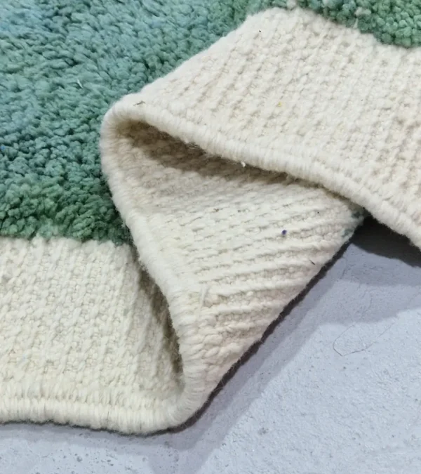Detailed View of Johana handmade Moroccan wool rug with a modern dotted pattern and two-tone green and ivory design