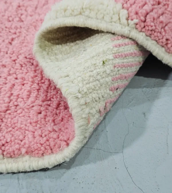 Detailed View of Juju handmade Moroccan wool rug with a contemporary geometric pattern in pink and ivory