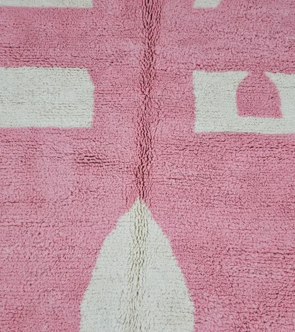 Detailed View of Juju handmade Moroccan wool rug with a contemporary geometric pattern in pink and ivory