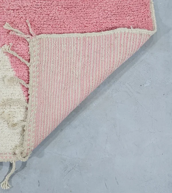 Detailed View of Juju handmade Moroccan wool rug with a contemporary geometric pattern in pink and ivory