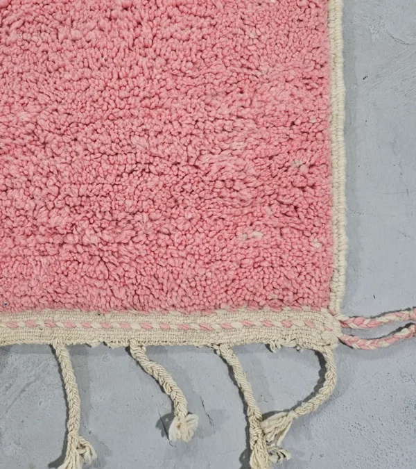 Detailed View of Juju handmade Moroccan wool rug with a contemporary geometric pattern in pink and ivory