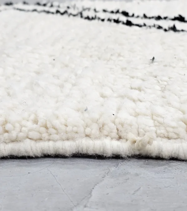 Zoomed In View of Kareen handmade Beni Ourain wool runner with a minimalist geometric zigzag design in black and ivory