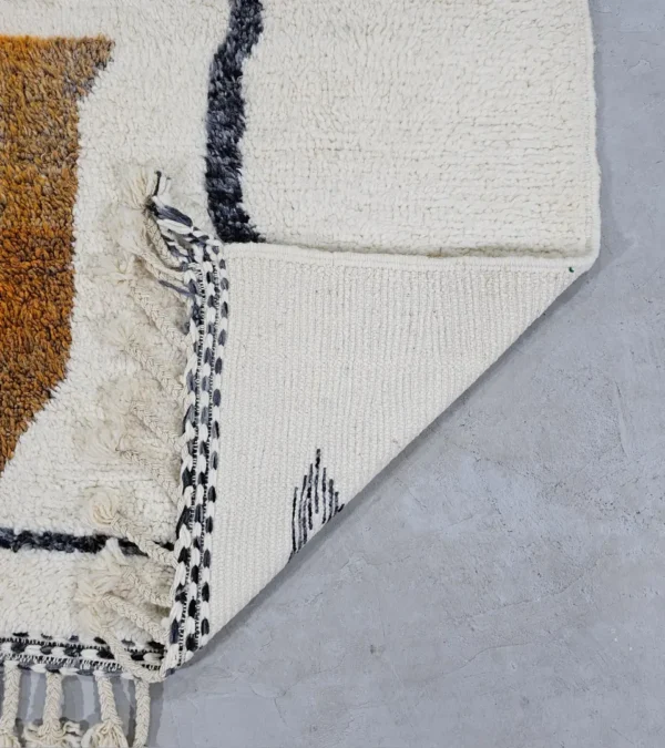 Detailed View of Kita handmade Beni Ourain wool rug with a minimalist abstract design in brown, black, and ivory