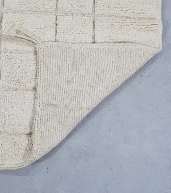 Detailed View of Lara handmade Beni Mrirt wool rug with a minimalist grid pattern in ivory created with a high/low pile