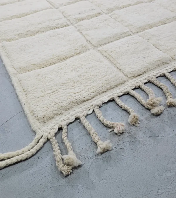 Detailed View of Lara handmade Beni Mrirt wool rug with a minimalist grid pattern in ivory created with a high/low pile
