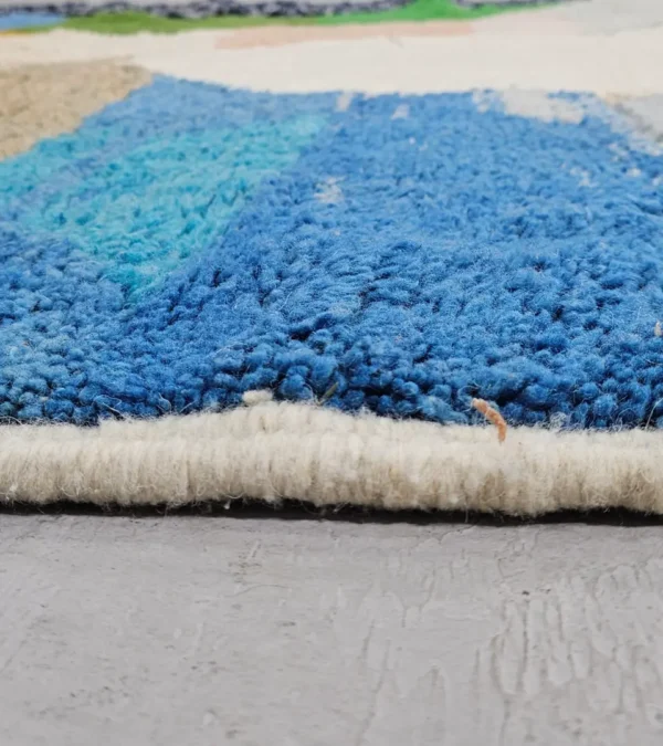 Zoomed In View of Leila handmade Beni Mrirt wool rug with a contemporary abstract patchwork design in multicolor, including brown, blue, yellow, and gray