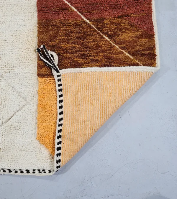 Detailed View of Leila handmade Beni Mrirt wool rug with a contemporary abstract patchwork design in multicolor, including brown, blue, yellow, and gray