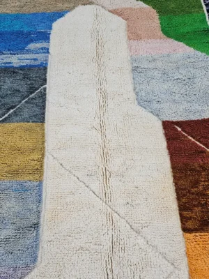 Detailed View of Leila handmade Beni Mrirt wool rug with a contemporary abstract patchwork design in multicolor, including brown, blue, yellow, and gray