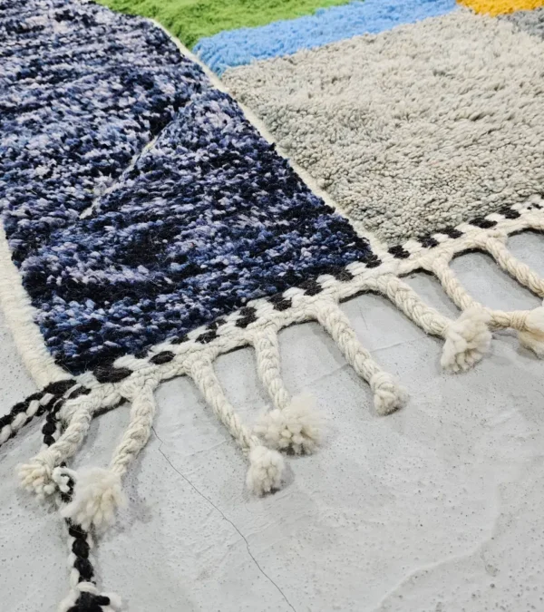 Detailed View of Leila handmade Beni Mrirt wool rug with a contemporary abstract patchwork design in multicolor, including brown, blue, yellow, and gray