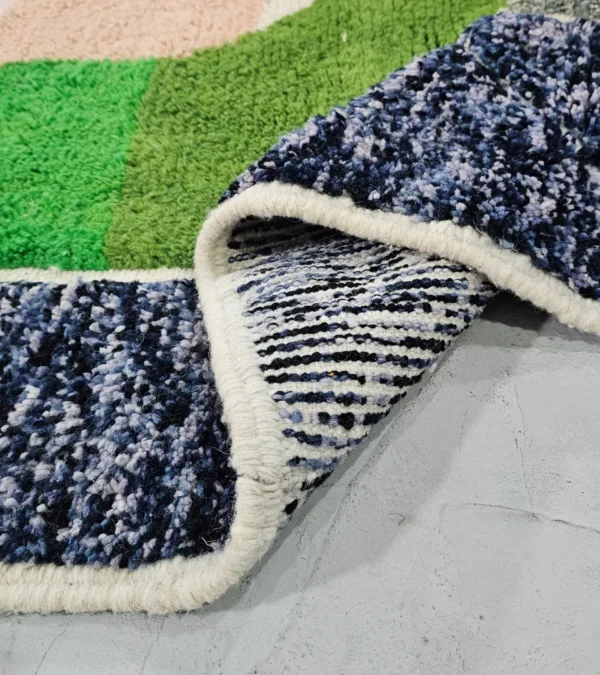 Detailed View of Leila handmade Beni Mrirt wool rug with a contemporary abstract patchwork design in multicolor, including brown, blue, yellow, and gray