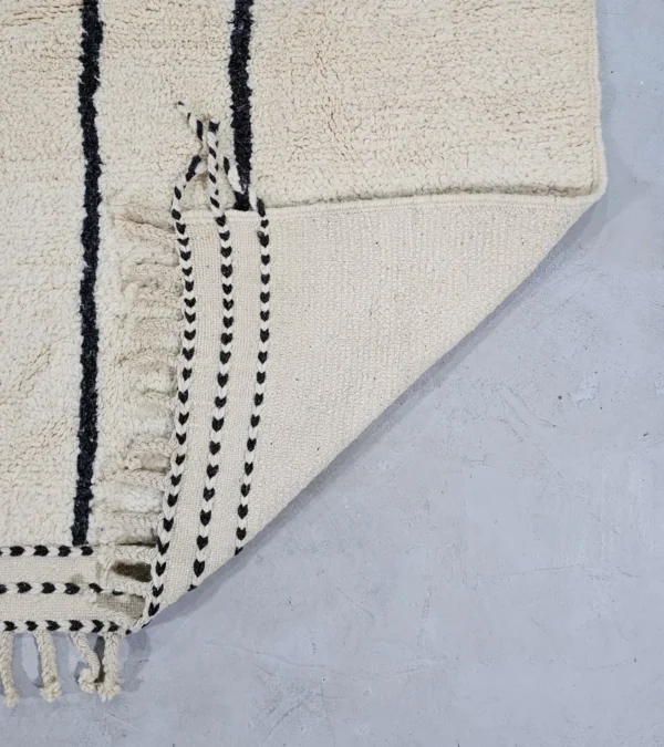 Detailed View of Lina handmade Beni Ourain wool rug with a geometric lined design in black, ivory, blue, pink, orange, and teal