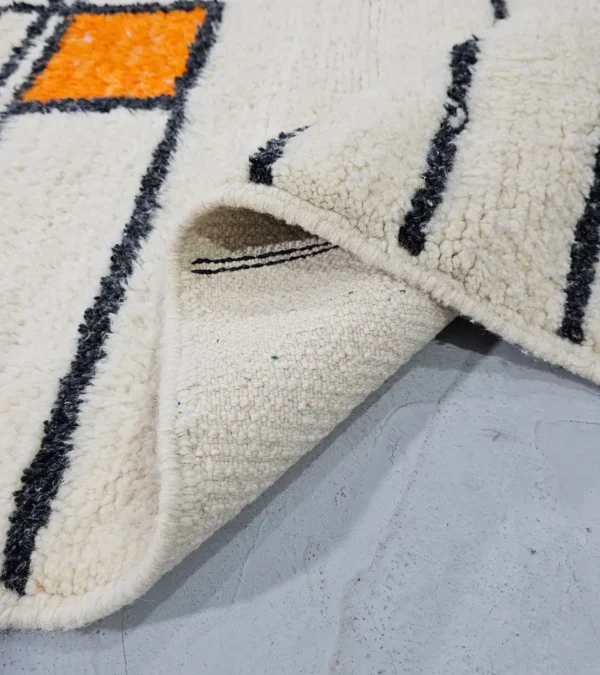 Detailed View of Lina handmade Beni Ourain wool rug with a geometric lined design in black, ivory, blue, pink, orange, and teal