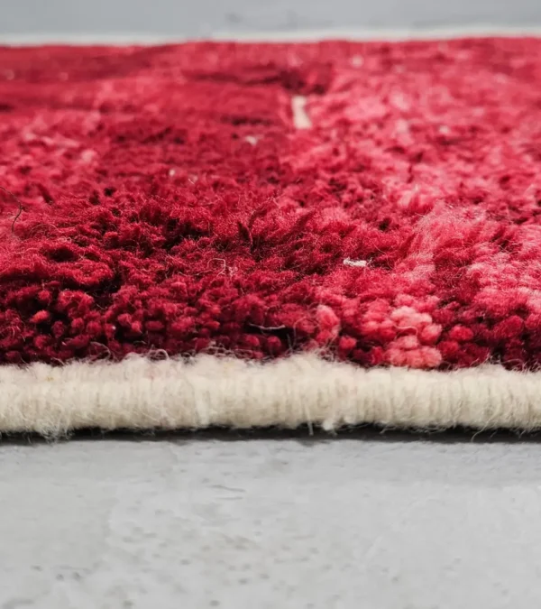 Zoomed In View of Lina handmade Beni Mrirt wool rug with an abstract lined design in red and ivory