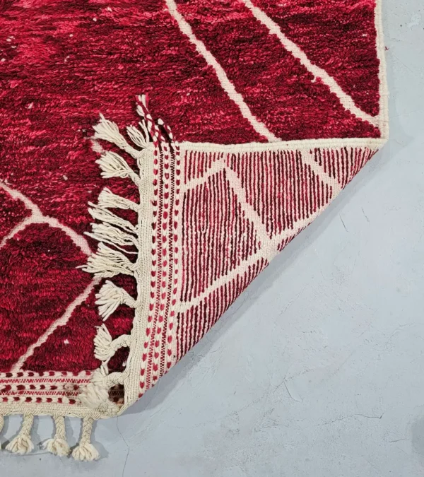 Detailed View of Lina handmade Beni Mrirt wool rug with an abstract lined design in red and ivory