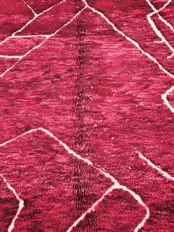 Detailed View of Lina handmade Beni Mrirt wool rug with an abstract lined design in red and ivory