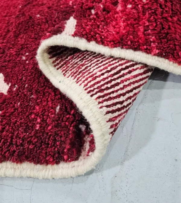 Detailed View of Lina handmade Beni Mrirt wool rug with an abstract lined design in red and ivory