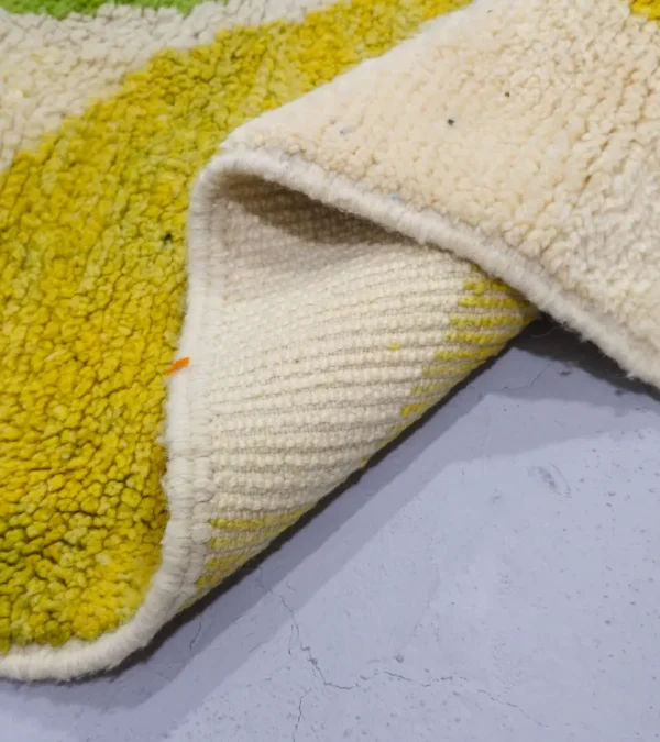Detailed View of Liora handmade Beni Ourain wool rug with a vibrant abstract design in green, blue, yellow, and pink