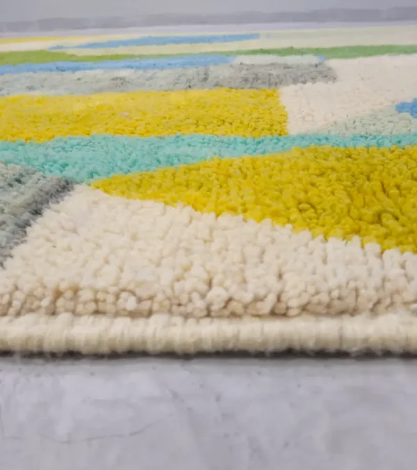 Zoomed In View of Liora handmade Beni Ourain wool rug with a vibrant abstract design in green, blue, yellow, and pink