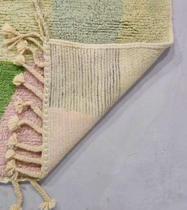 Detailed View of Liora handmade Beni Ourain wool rug with a vibrant abstract design in green, blue, yellow, and pink