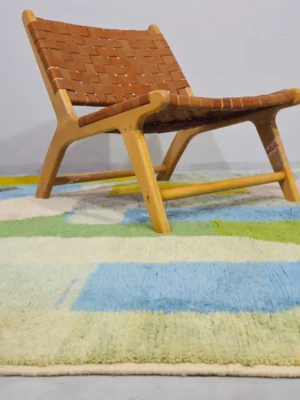 Liora handmade Beni Ourain wool rug with a vibrant abstract design in green, blue, yellow, and pink in room
