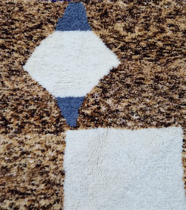 Detailed View of Luna handmade Beni Ourain wool rug with a boho brown background and a geometric pattern in ivory and blue