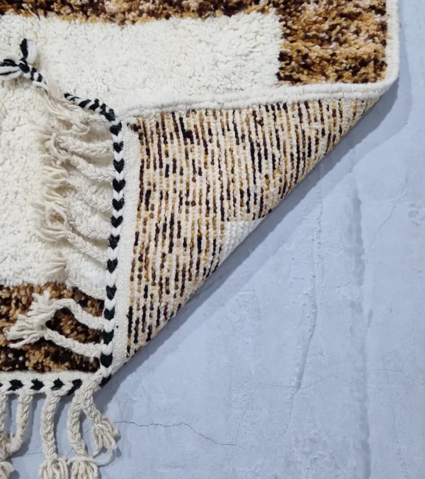 Detailed View of Luna handmade Beni Ourain wool rug with a boho brown background and a geometric pattern in ivory and blue