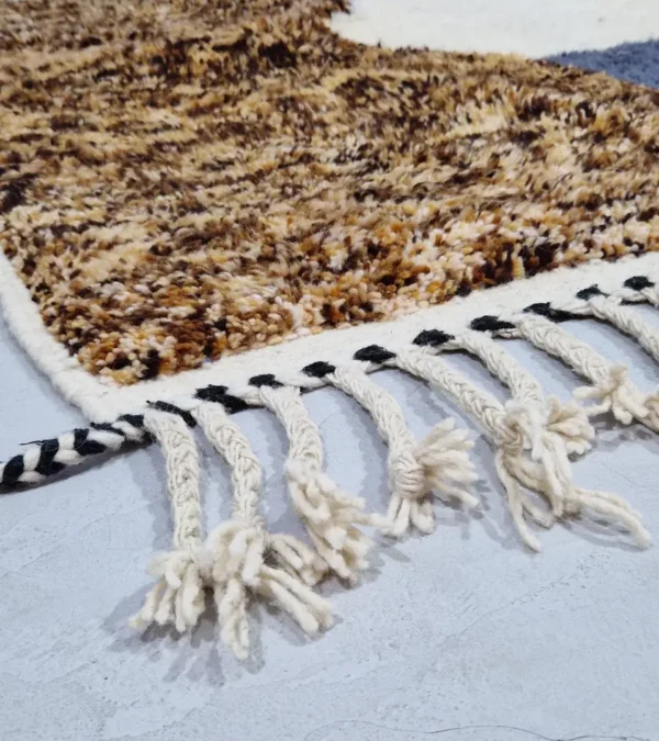 Detailed View of Luna handmade Beni Ourain wool rug with a boho brown background and a geometric pattern in ivory and blue