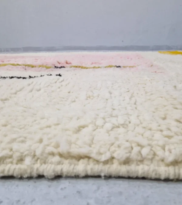 Zoomed In View of Handmade Moroccan wool rug with an abstract colorblock design in pink, yellow, and black