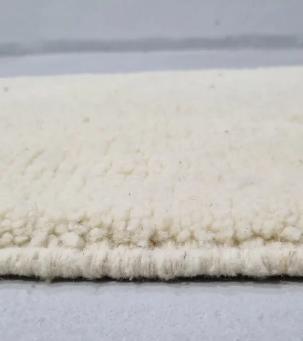 Zoomed In View of Handmade Beni Ourain wool runner with a minimalist lattice design created by high-low pile in ivory