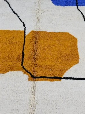 Detailed View of Handmade Moroccan wool rug with blue and mustard abstract design and black outline