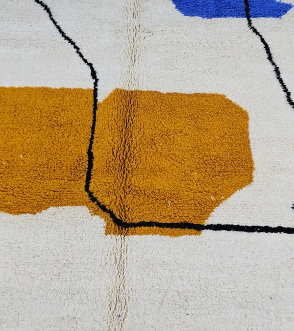 Detailed View of Handmade Moroccan wool rug with blue and mustard abstract design and black outline