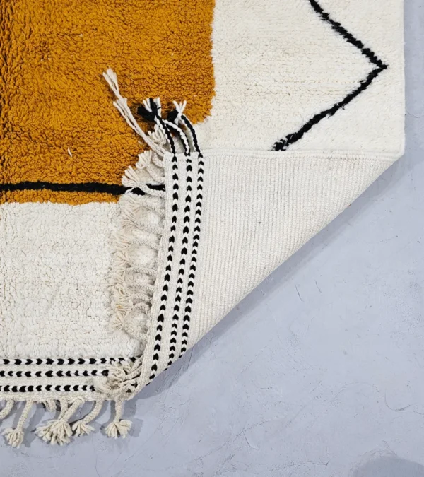 Detailed View of Handmade Moroccan wool rug with blue and mustard abstract design and black outline