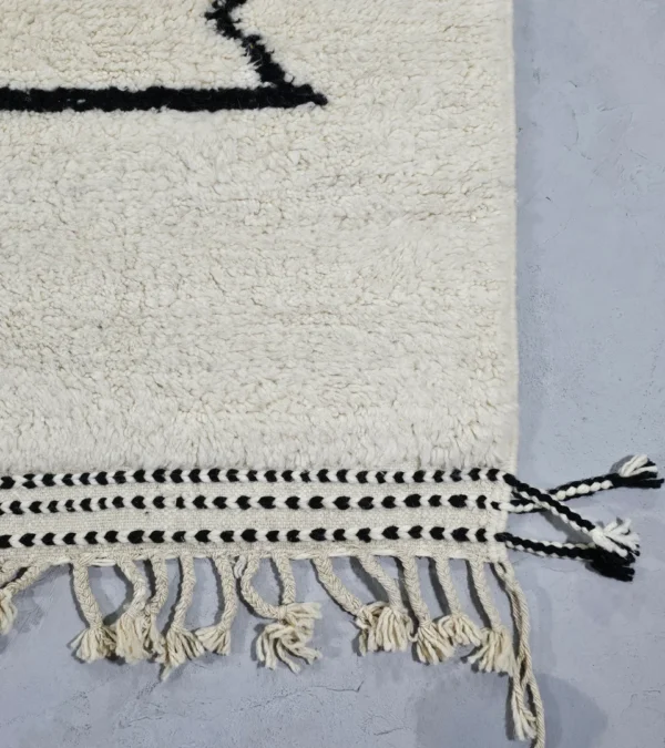 Detailed View of Handmade Moroccan wool rug with blue and mustard abstract design and black outline