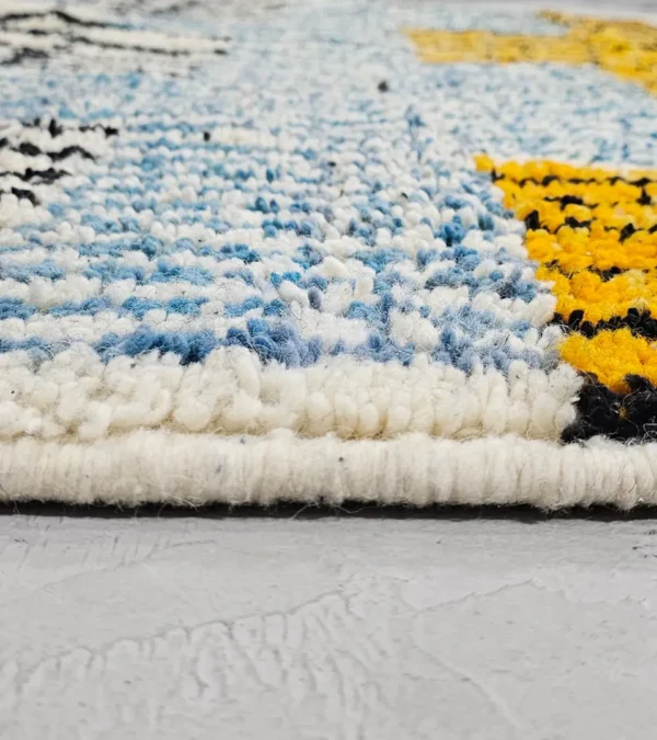 Zoomed In View of Nareen handmade Beni Mrirt wool rug with a contemporary bohemian abstract geometric design in blue, yellow, and black