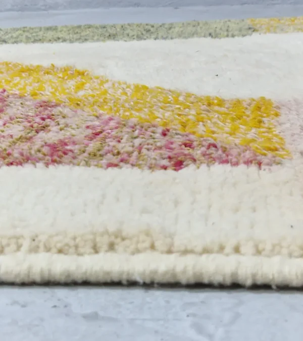 Zoomed In View of Naya handmade Azilal wool rug with a contemporary color blocks design in yellow, green, pink, brown, and ivory