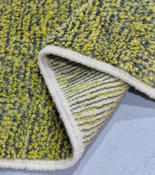Detailed View of Naya handmade Azilal wool rug with a contemporary color blocks design in yellow, green, pink, brown, and ivory
