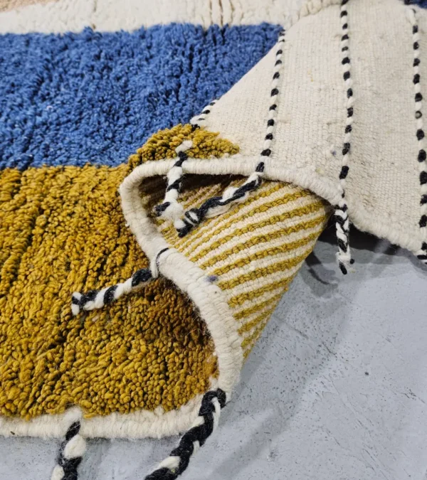 Detailed VIew of Nayla handmade Beni Ourain wool rug with a vibrant multicolor geometric design and a high/low textured pile