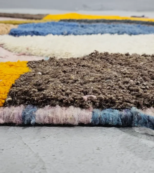 Zoomed In View of Nayla handmade Beni Ourain wool rug with a colorful geometric design and tassels